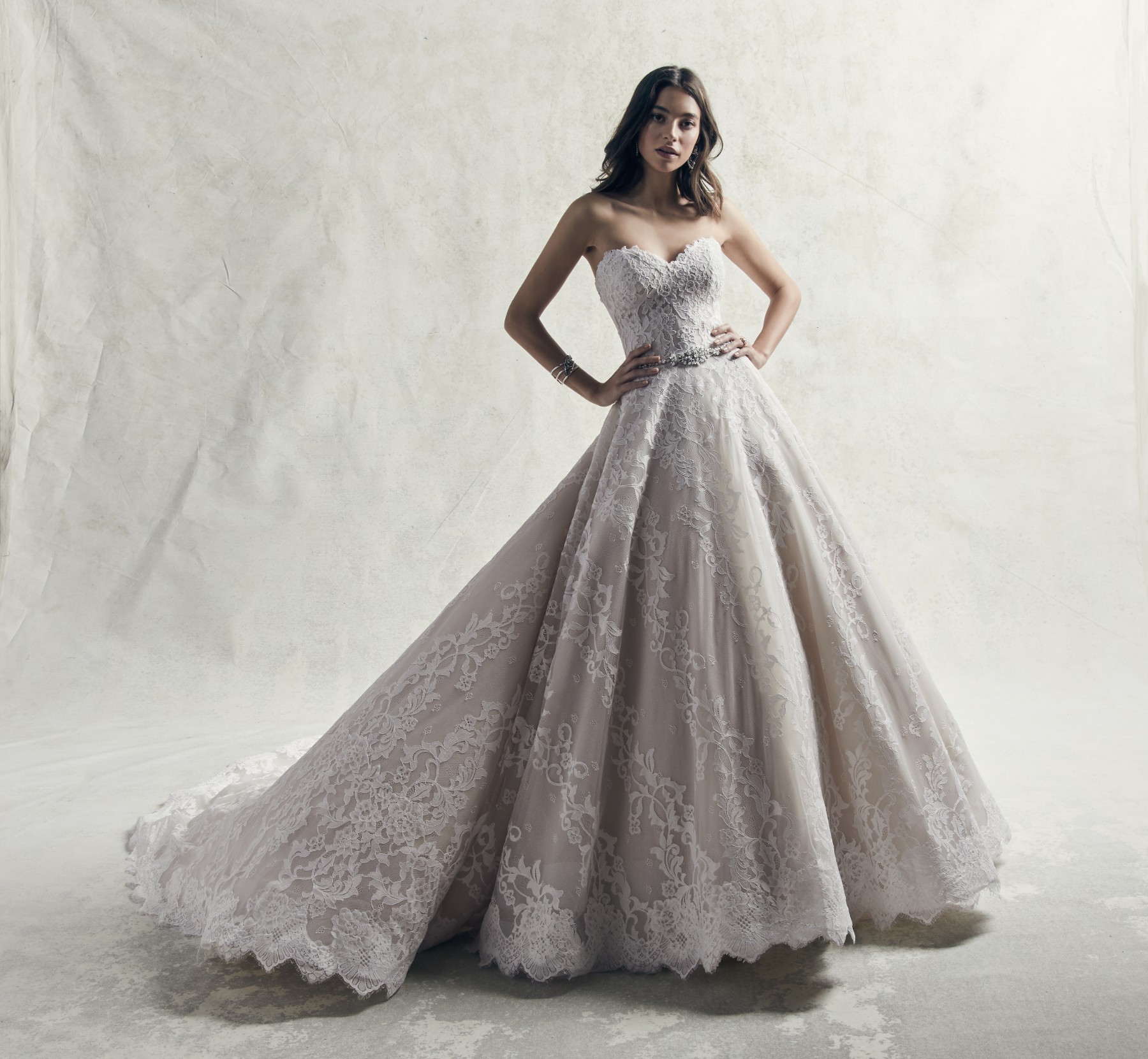 Pormenores de renda românticos dão destaque a este vestido de noiva com corte princesa. Sem alças e com decote em forma de coração. 