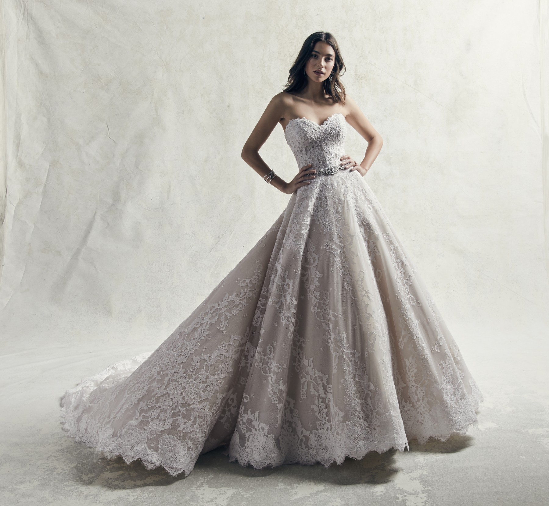 Pormenores de renda românticos dão destaque a este vestido de noiva com corte princesa. Sem alças e com decote em forma de coração.