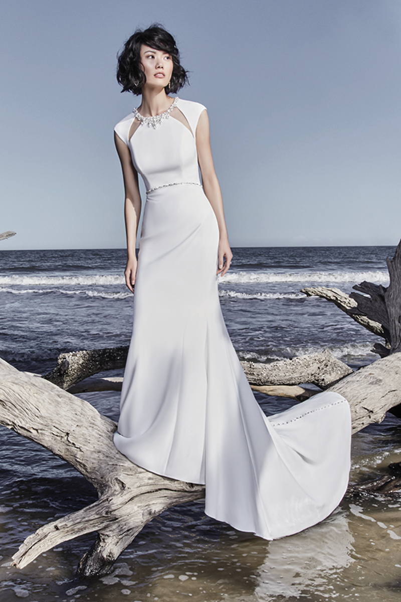 Este vestido de noiva remonta-nos para o glamour do Antigo Hollywood, ao apresentar uma mangas curtas e uma abertura nas costas, realçada com cristais Swarovski. Recortes com efeito ilusão na zona do pescoço, decorada com jóias, o que confere o toque final deste sexy, mas elegante vestido. Terminado com botões de cristais e um fecho.
<a href="https://www.maggiesottero.com/sottero-and-midgley/arleigh-rose/11517">Sottero and Midgley</a>