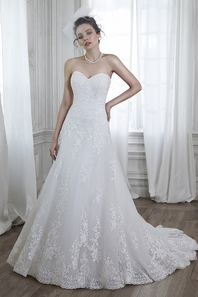 Vestido de noiva com tule e aplicações de renda, um decote subtil com acabamento com botões sobre o zipper e fecho elástico interior.
<a href="http://www.maggiesottero.com/dress.aspx?style=5MB026" target="_blank">Maggie Sottero Spring 2015</a>