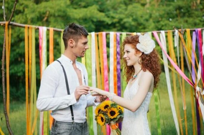 Noivos pousam junto ao altar colorido. Foto: Bell Studio.
