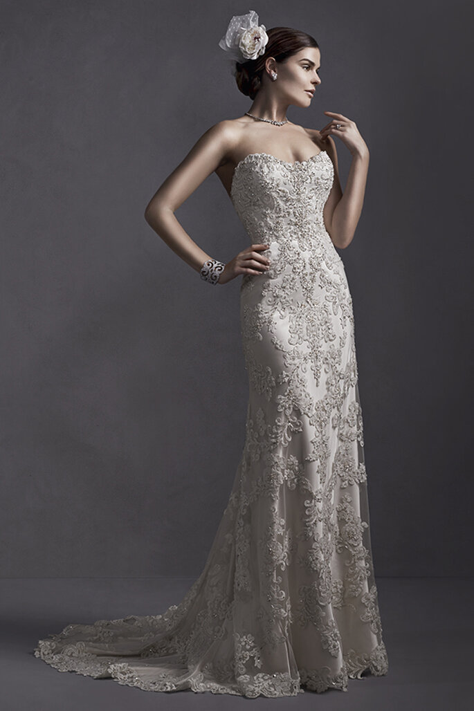 Vestido de noiva de renda, enfeitado com cristais Swarovski e decote coração. Acabamento com coberta de botões de cristal sobre o zíper e espartilho interior.
<a href="http://www.sotteroandmidgley.com/dress.aspx?style=5SR053" target="_blank">Sottero and Midgley Spring 2015</a>