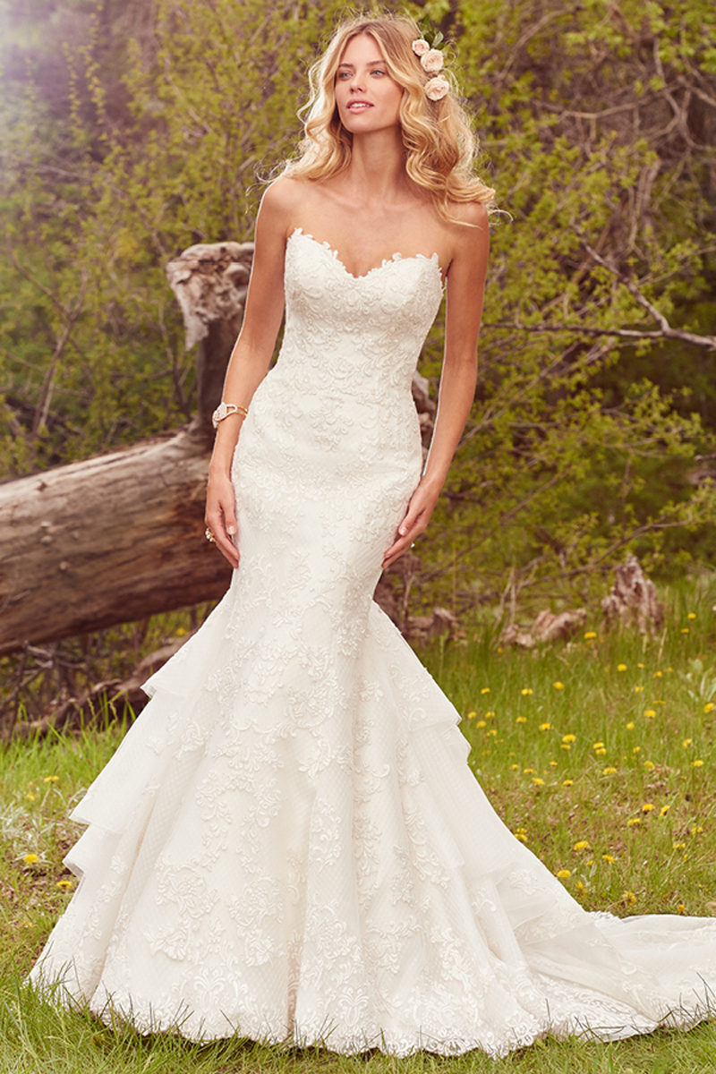 Este glamoroso vestido apresenta uma camada de detalhes em renda que se complementa com um decote em forma de coração se mangas. Terminado com botões de cristais no fecho e no interior do espartilho.
<a href="https://www.maggiesottero.com/maggie-sottero/goldie/10099?utm_source=mywedding.com&utm_campaign=spring17&utm_medium=gallery" target="_blank">Maggie Sottero</a>