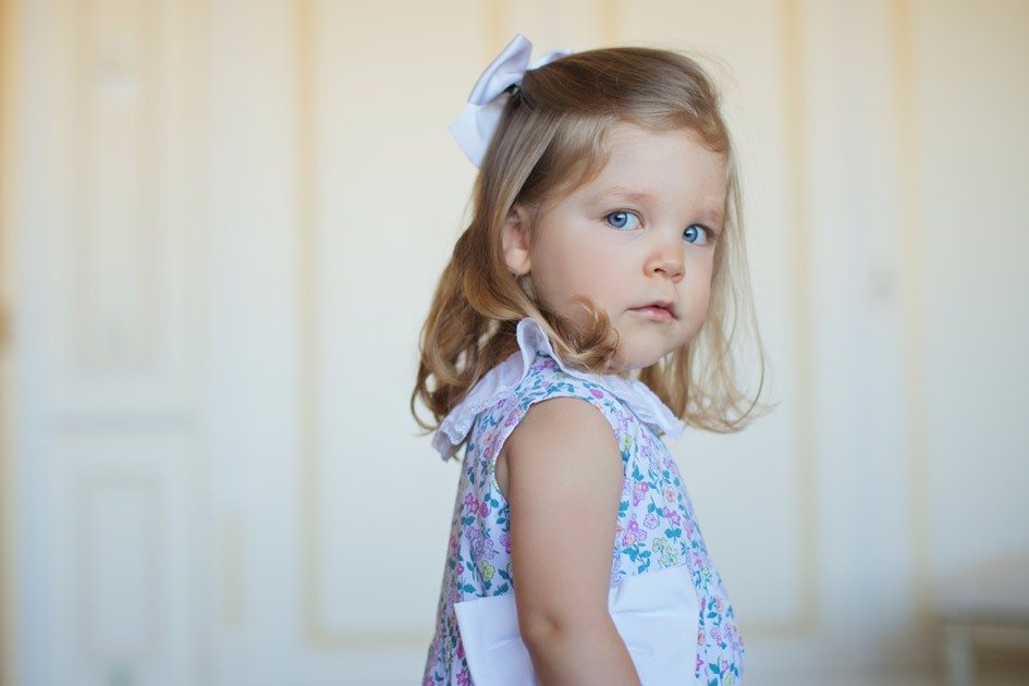 menina loura olhos azuis com vestido flores e laço na cabeça vestido festa casamento