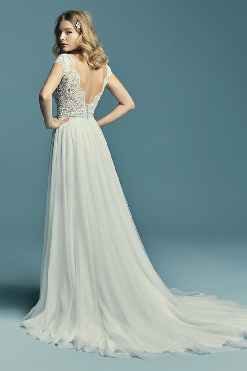 <a href="https://www.maggiesottero.com/maggie-sottero/monarch/11498">Maggie Sottero</a>
Pormenores de renda delicados caracterizam este vestido de noiva com estilo boho. Decote em forma de V com efeito ilusão e umas costas em perfeito V. Os cristais Swarovski adornam o bodu, assim como o detalhe do cinto. Saia linha-A confecionada com tule. Terminado com botões cobertos sobre fecho.