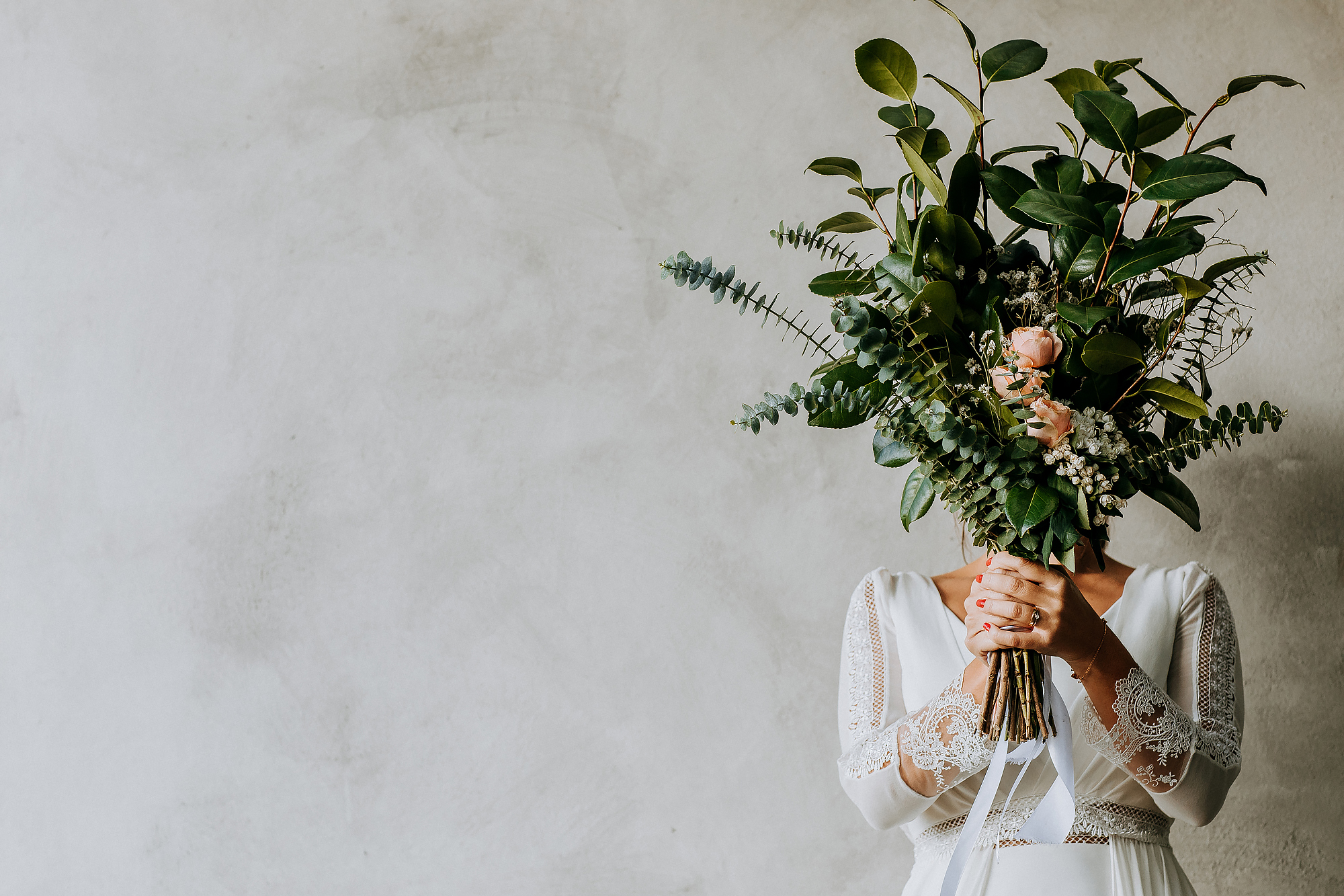 noiva com grande bouquet de flores à frente da cara