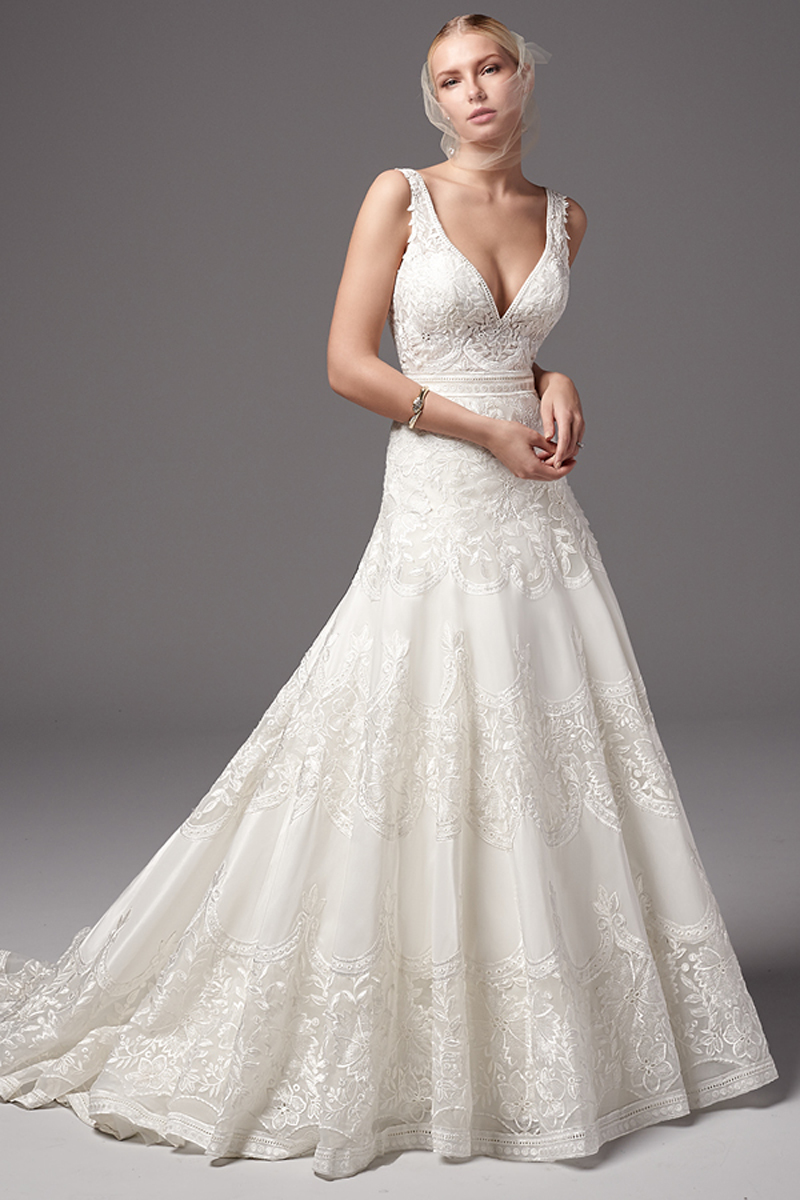 Este vestido Ettore taffeta de Linha A apresenta um bordado de renda. As alças correm desde o magnífico decote em V até ao decote, também, em V das costas, completando o drama intrigante deste look. Terminado com botões em vez do fecho.
<a href="https://www.maggiesottero.com/sottero-and-midgley/nisha/10245?utm_source=mywedding.com&utm_campaign=spring17&utm_medium=gallery" target="_blank">Sottero and Midgley</a>