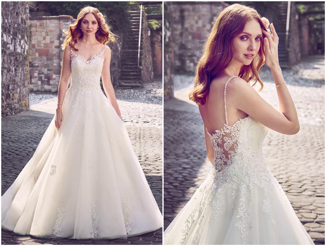 Elegante vestido estilo princesa, composto por camadas de renda com motivos de pedraria sobre camadas de tule, com decote coração à frente, que termina em decote ilusão nas costas. Embelezado por cristais Swarovski e acabamentos de botões de cristal por cima de fecho zíper. <a href="https://www.maggiesottero.com/maggie-sottero/amara/11152?utm_source=zankyou&utm_medium=gowngallery" target="_blank">Maggie Sottero</a>