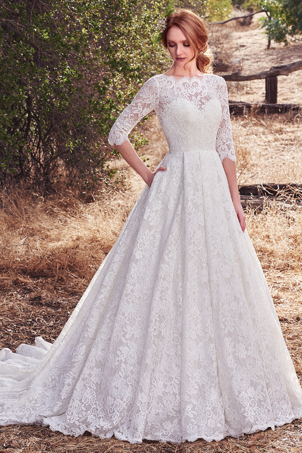 Este deslumbrante e elegante vestido de noiva é confeccionado totalmente com renda, decote em forma de barco e costas em forma de quadrado. Um glamour que nos remonta para as inpsirações mais vintage. Um vestido que exibe, ainda, bolsos na cintura e com acabamentos de botões