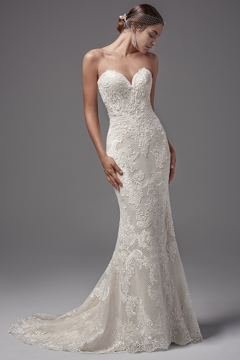 Este intrigante fit-and-flare apresenta detalhes em renda luxuosos e rendado. Decote em forma de coração e abertura em V nas costas. Terminado com botões em vez do fecho.
<a href="https://www.maggiesottero.com/sottero-and-midgley/ellington/10217?utm_source=mywedding.com&utm_campaign=spring17&utm_medium=gallery" target="_blank">Sottero and Midgley</a>