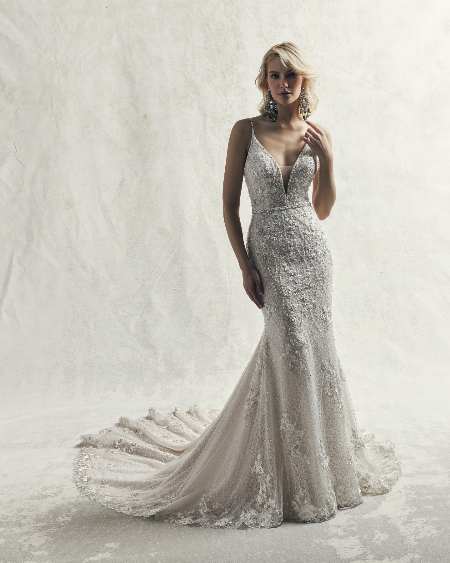 Este vestido de noiva sexy fit-and-flare apresenta pérolas e motivos de renda sobre tule.