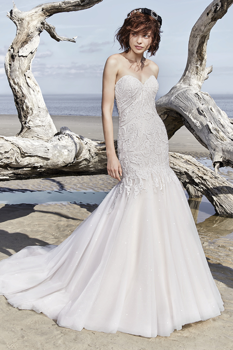 Este vestido de noiva extremamente sexy apresenta um corpete com detalhes bordados de renda, que cai ao longo de um saia brilhante de tule. Um decote em coração sem alças confere um toque especial ao modelo. Terminado com botões que cobrem o fecho. Mangas com bordados de renda vendidos em separado.
<a href="https://www.maggiesottero.com/sottero-and-midgley/brette/11524">Sottero and Midgley</a>