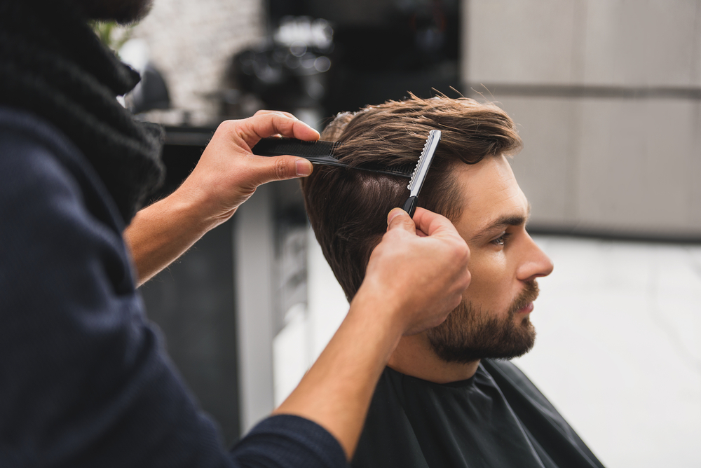 homem a ser penteado barbeiro cabeleireiro