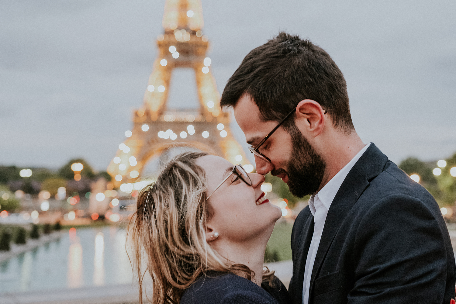 casal de namorados cumplices em frente à torre eiffel paris frança