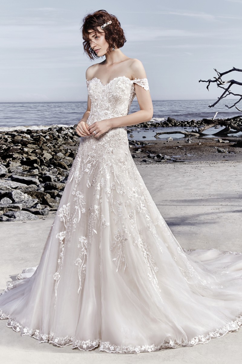 <a href="https://www.maggiesottero.com/sottero-and-midgley/laramie/11548">Maggie Sottero</a>

A espetacular renda rebordada com contas recai sobre o tule neste vestido de noiva evasê romântico, arrematando o decote sem alças.