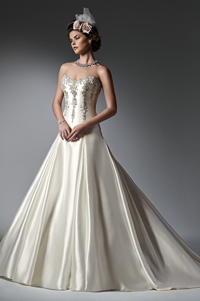 Dramático e sofisticado, este vestido de noiva LinhaA e Mikado Elodie apresenta detalhes metálicos na renda bordada e cristais Swarovski enfeitam, em conjunto, o corpete. Uma saia plissada com bolsos. Terminado com espartilho.
<a href="https://www.maggiesottero.com/sottero-and-midgley/vanessa/9573" target="_blank">Sottero and Midgley</a>