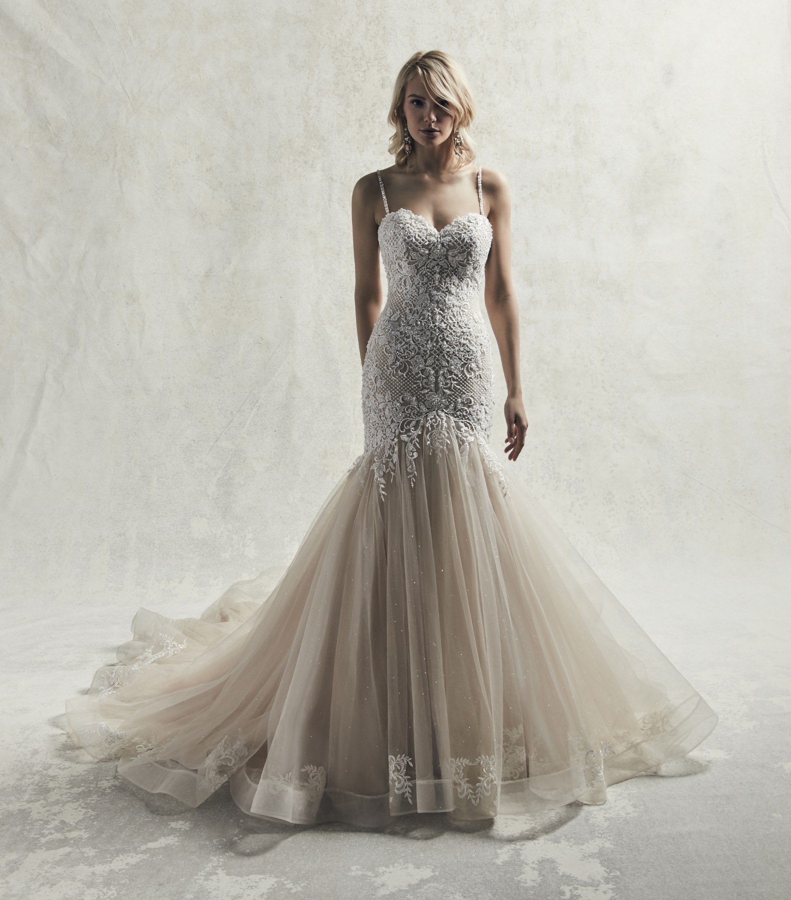 Este vestido de noiva com corte de sereia é acentuada com pormenores de renda bordados e cristais Swarovski.