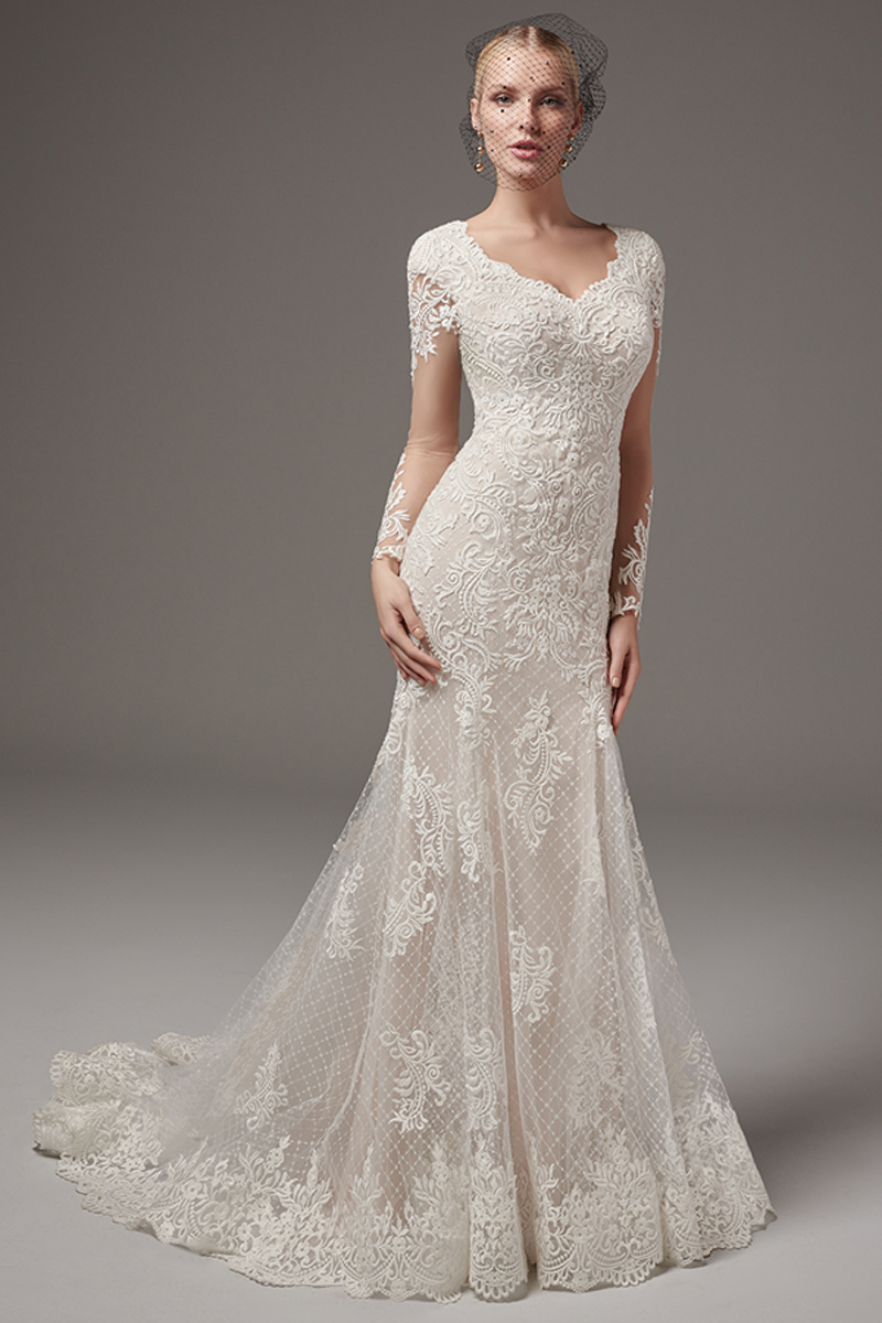 Pormenores rendados dançam ao longo de um tule com padrão cruzado neste vestido fit-and-flare chic. Decote em forma de coração, mangas compridas. Terminado com botões em vez do fecho.
<a href="https://www.maggiesottero.com/sottero-and-midgley/melrose-lynette/10241?utm_source=mywedding.com&utm_campaign=spring17&utm_medium=gallery" target="_blank">Sottero and Midgley</a>