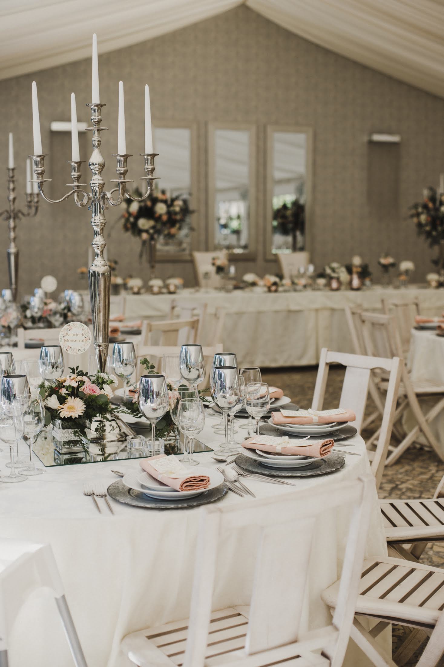 sala casamento em tons pasteis com candelabros nas mesas