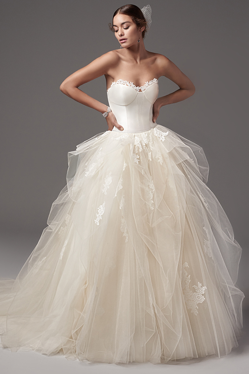 Com um corpete Yakon Mikado inspirado em lingerie apresenta renda na costura ao longo do decote em forma de coração. O corpete pode ser vestido por baixo ou por cima da costura da cintura que constitui esta saia com efeito balão com camadas volumosas de tule. Terminado com botões em vez do fecho.
<a href="https://www.maggiesottero.com/sottero-and-midgley/foster-rose/10223?utm_source=mywedding.com&utm_campaign=spring17&utm_medium=gallery" target="_blank">Sottero and Midgley</a>