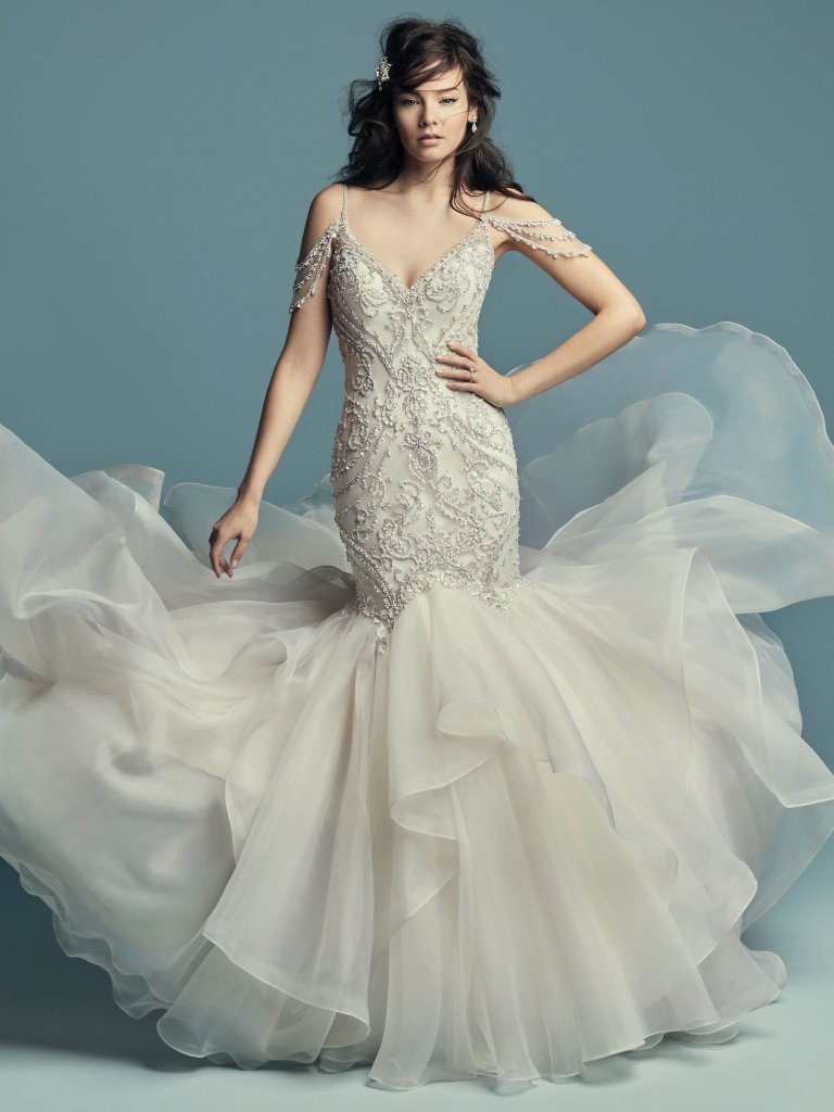 <a href="https://www.maggiesottero.com/maggie-sottero/brinkley/11427">Maggie Sottero</a>


Glamoroso e inspirado no estilo vintage, este vestido de noiva com corte de sereia é confecionado com tule, cujo corpete é realçado com cristais Swarovski. Decote em forma de coração e profundo decote em V nas costas. Saia fit-and-flare constituída por Organza chic. Terminado com botões de cristal sobre um fecho. 

