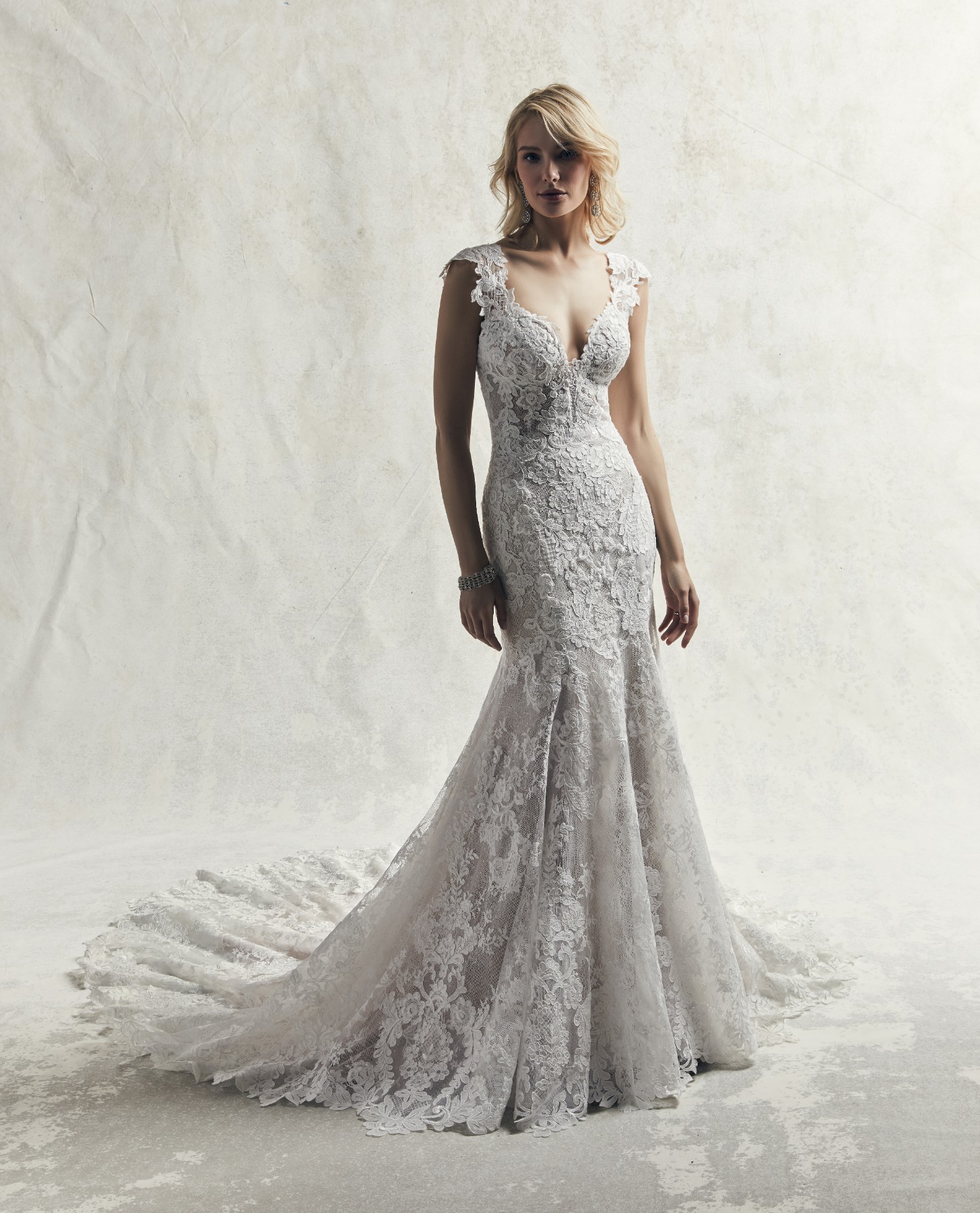 Sensual e romântico: assim é este vestido de noiva com corte de sereia que exiba renda ao longo de todo o modelo, tule com textura que cai em cascada ao longo da saia fit-and-flare.