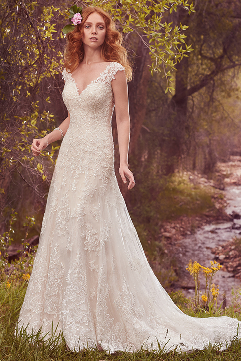 Este modelo brilhante apresenta uma camada com renda delicada sobre uma camada de renda que ocupa todo o vestido. Mangas curtas, decote em forma de coração. Terminado com botões no fecho.
<a href="https://www.maggiesottero.com/maggie-sottero/tabrett/10145?utm_source=mywedding.com&utm_campaign=spring17&utm_medium=gallery" target="_blank">Maggie Sottero</a>