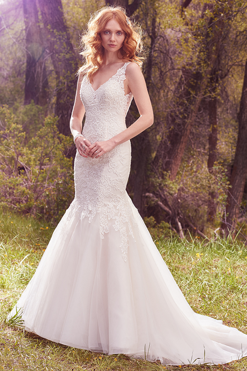 Pormenores com renda combinados com pérolas e contas que adornam o corpete que apresenta um decote em V. Tule sobre a saia confeccionada com Chic Organza. 
<a href="https://www.maggiesottero.com/maggie-sottero/chardonnay/10094?utm_source=mywedding.com&amp;utm_campaign=spring17&amp;utm_medium=gallery" target="_blank">Maggie Sottero</a> 
