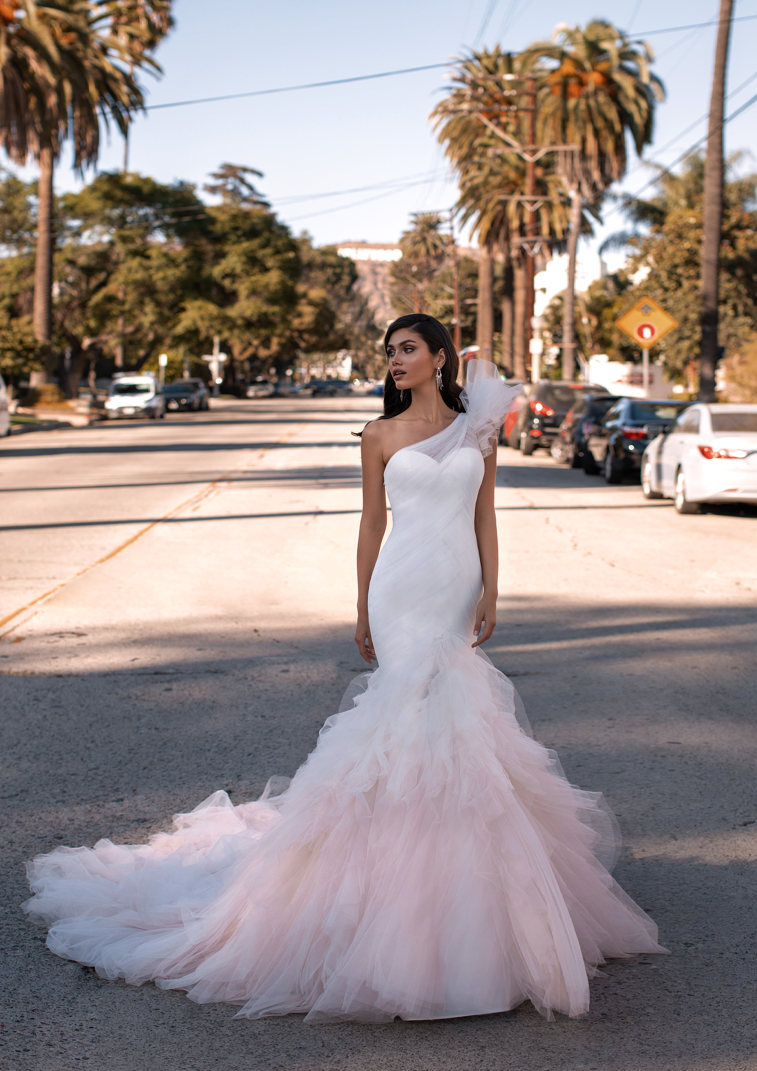 Um vestido de verdadeira estrela de cinema, com torso ajustado de tule drapeado, detalhe no ombro ultraglamouroso e uma saia rodada em tom rosado. | Modelo Neal de Pronovias 2021 Cruise Collection – Ashley Graham X Pronovias