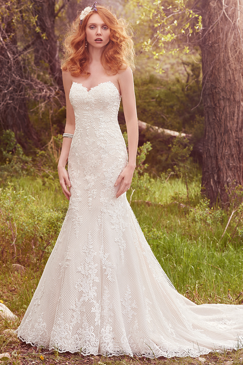 Uma renda amorosa com efeito cascata sobre um tule cruzado num modelo típico de fit-and flare, apresentado uma renda esplêndida, um decote em forma de coração. Terminado com botões na zona do fecho.
<a href="https://www.maggiesottero.com/maggie-sottero/makenna/10121?utm_source=mywedding.com&utm_campaign=spring17&utm_medium=gallery" target="_blank">Maggie Sottero</a>