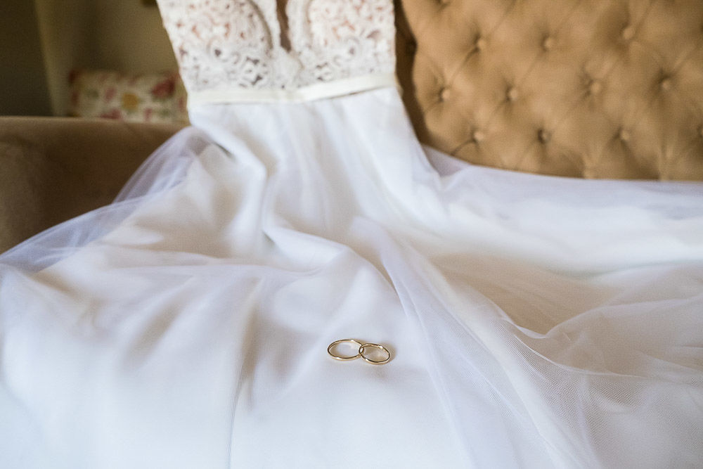 alianças de casamento em cima do vestido de noiva