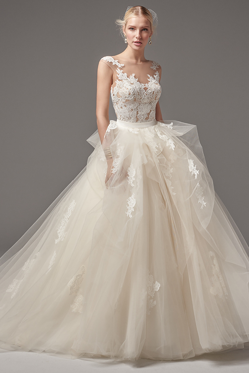 Este sexy e romântico vestido que assenta perfeitamente no corpo apresenta alguns detalhes dispersos em renda e um decote em forma de coração, mangas curtas e um efeito de costas abertas. Terminado com botões de cristal. Um vestido com saia balão apresenta várias camadas volumosas de tule, detalhes de renda e terminado com um fecho.
<a href="https://www.maggiesottero.com/sottero-and-midgley/tristan---gemma/10298?utm_source=mywedding&utm_campaign=spring2017&utm_medium=gallery" target="_blank">Sottero and Midgley</a>
