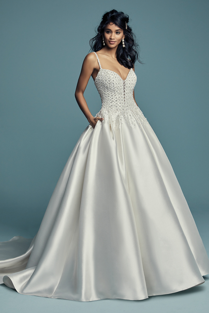 <a href="https://www.maggiesottero.com/maggie-sottero/dana/11464">Maggie Sottero</a>
Delicados pormenores bordados decoram este vestido de noiva Elodie Mikado com corte princesa. Alças finas com pormenores bordados completam o decote profundo em forma de coração. Terminado com botões de cristal sobre um fecho.