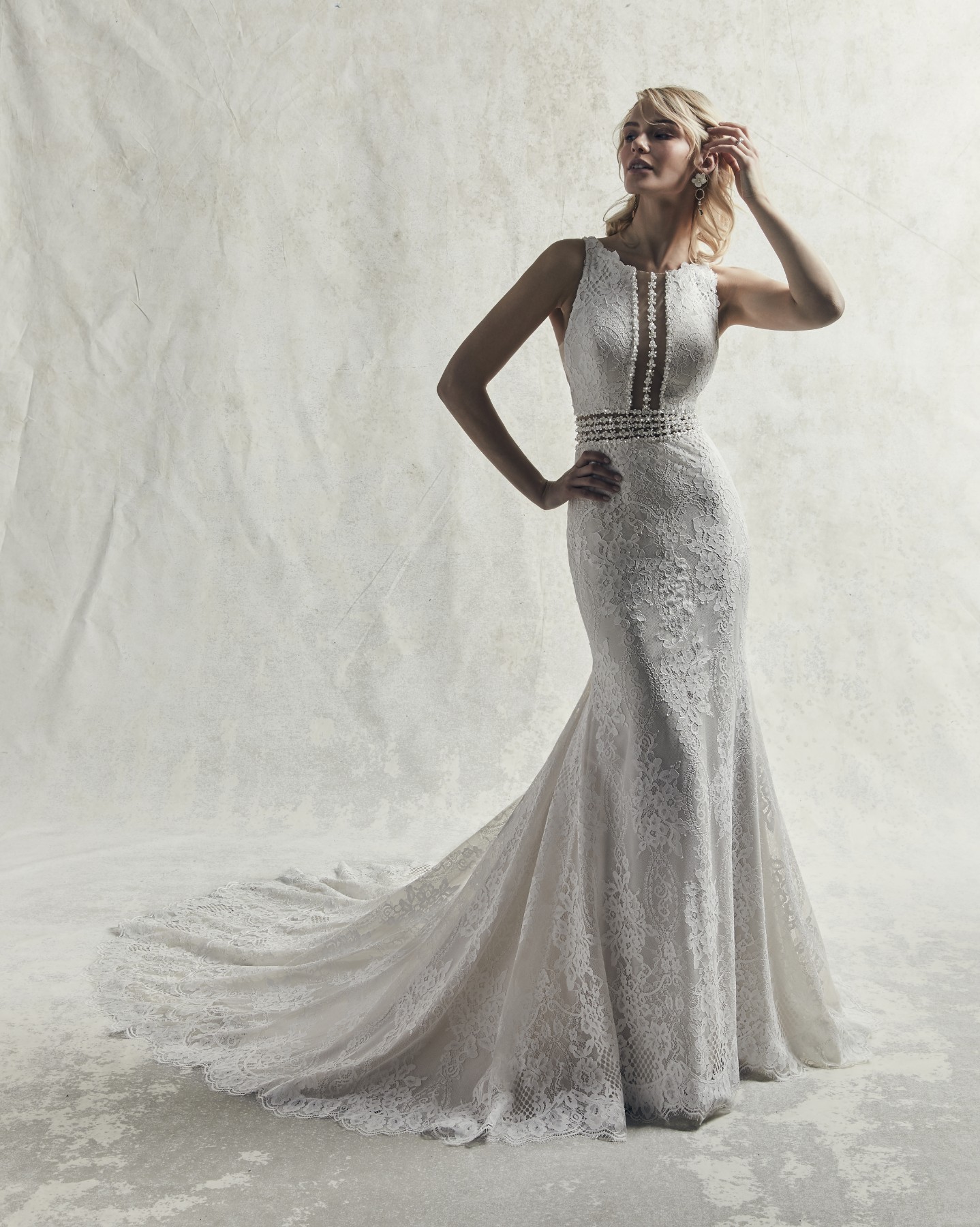 Este vestido de noiva apresenta um decote com joias, Efeito ilusão na linha da cintura. 