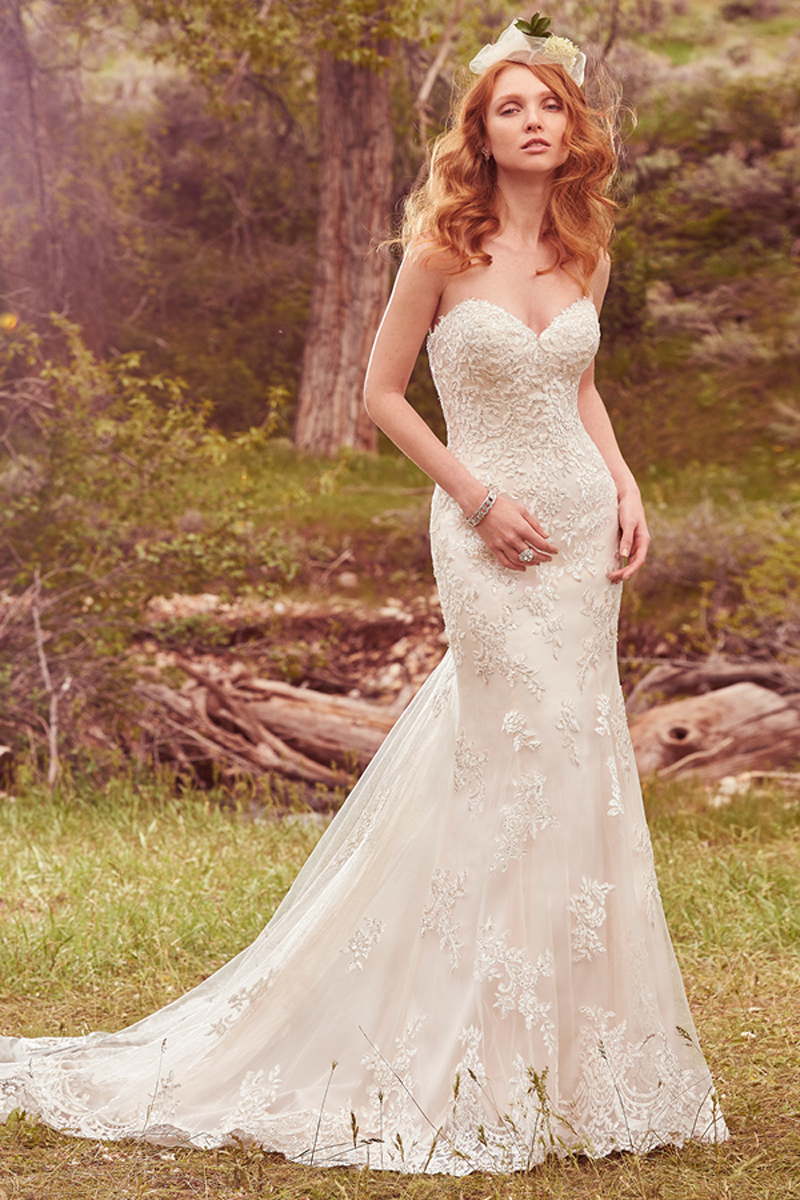 Um efeito de cascata neste vestido com aplicações em renda juntamente com um decote em forma de coração muito sedutor com bainhas, também, em renda muito atraentes. Terminado com botões em cristais ou na zona do espartilho. Um casaco com efeito de renda de mangas curtas pode ser vendido separadamente.
<a href="https://www.maggiesottero.com/maggie-sottero/reynold/10136?utm_source=mywedding.com&utm_campaign=spring17&utm_medium=gallery" target="_blank">Maggie Sottero</a>