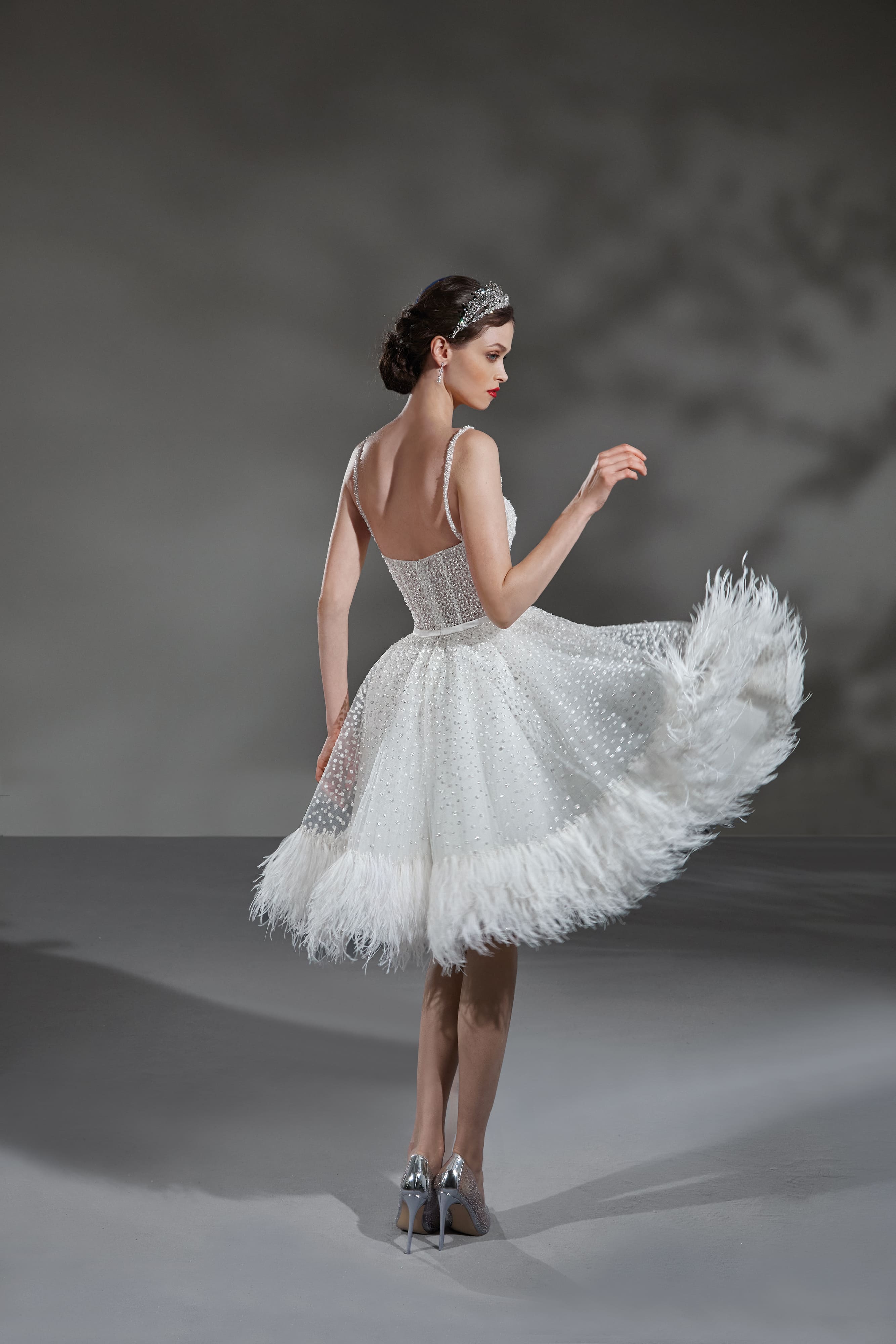 Modella di spalle con abiti da sposa corto firmato Alta Moda