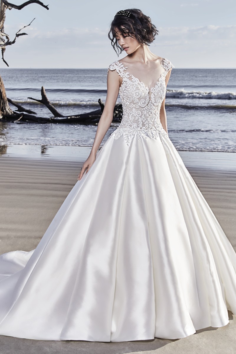 <a href="https://www.maggiesottero.com/sottero-and-midgley/huntington/11541">Maggie Sottero</a>
Lindos motivos de renda e cristais Swarovski adornam o corpete deste vestido de noiva princesa, mergulhando no decote V ilusão, sobre as cap sleeves, finalizando de forma delicada o decote das costas.