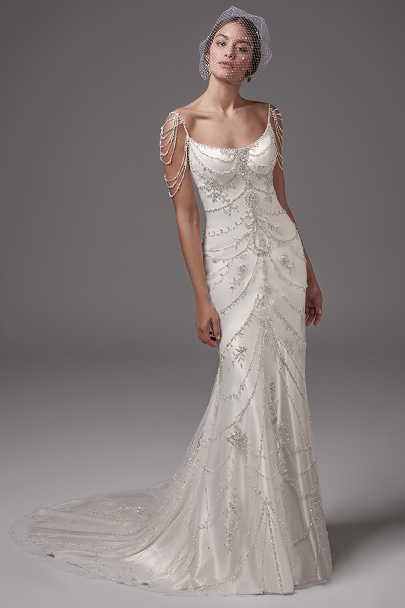 Este vestido de Cetim Ava inspirado num estilo vintage apresenta laços de pérolas e cristais Swarovski com alças e um tratamento especial nos ombros. Decote em forma de U e costas abertas convidam a uma sensualidade e sofisticação sem igual.
<a href="https://www.maggiesottero.com/sottero-and-midgley/dominique/10216?utm_source=mywedding.com&utm_campaign=spring17&utm_medium=gallery" target="_blank">Sottero and Midgley</a>