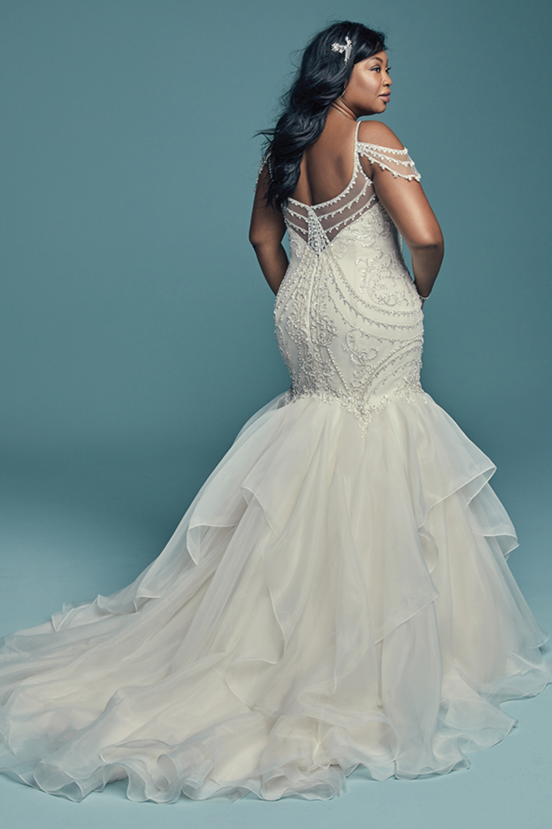 <a href="https://www.maggiesottero.com/maggie-sottero/brinkley-lynette/11459">Maggie Sottero</a>


Glamoroso e inspirado no estilo vintage, este vestido de noiva com corte de sereia é confecionado com tule, cujo corpete é realçado com cristais Swarovski. Decote em forma de coração e profundo decote em V nas costas. Saia fit-and-flare constituída por Organza chic. Terminado com botões de cristal sobre um fecho. 

