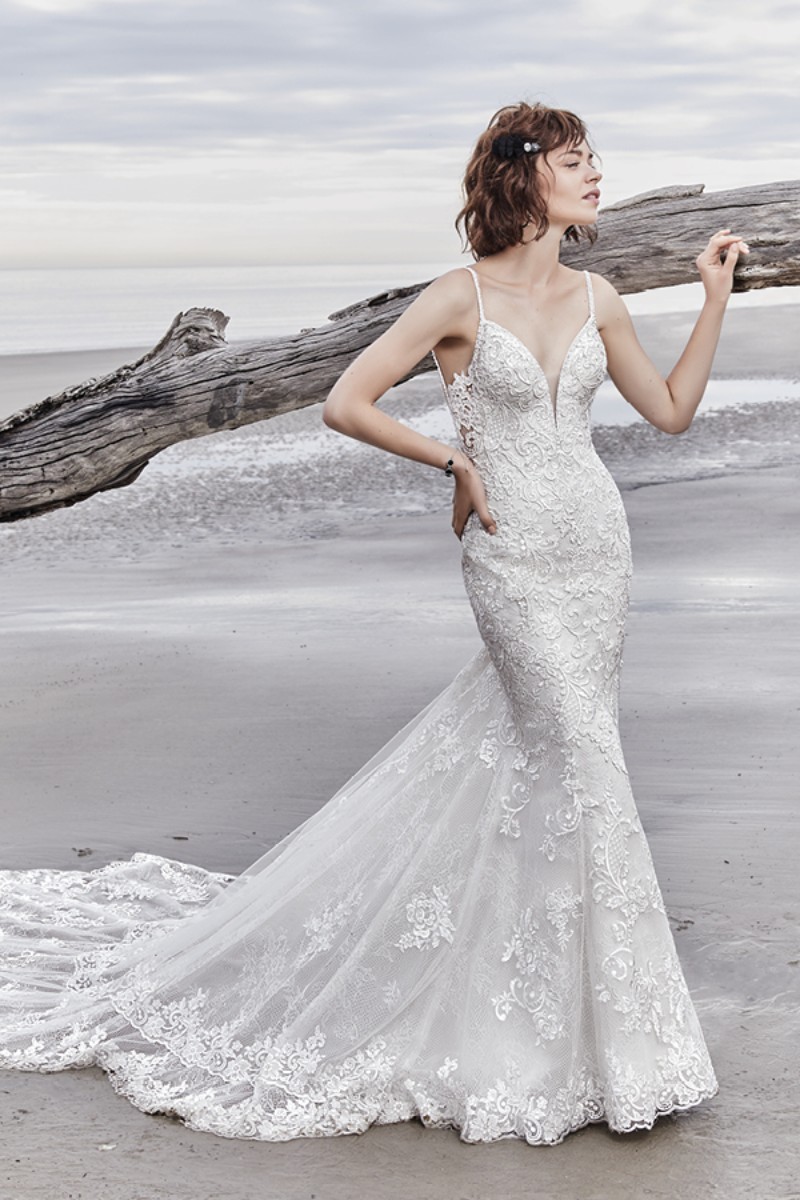 <a href="https://www.maggiesottero.com/sottero-and-midgley/sullivan-rose/11570">Maggie Sottero</a>
As tiras de contas criam um efeito cruzado duplo único na abertura das costas. Este modelo é complementado com uma saia dupla em transparência acentuada por motivos de renda.