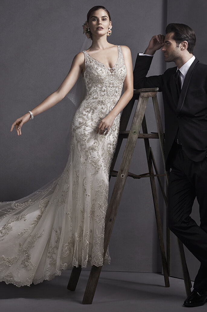 Vestido elegante de tubo com renda bordada com cristais Swarovski que baixam por uma saia de tule. Decote em V e coberta de botões de pérola sobre o zíper.
<a href="http://www.sotteroandmidgley.com/dress.aspx?style=5SW070" target="_blank">Sottero and Midgley Spring 2015</a>