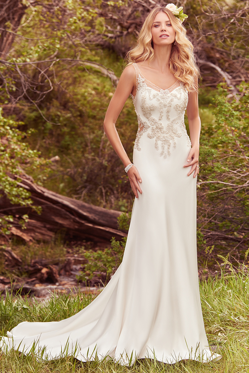 Lace appliqués embellished with pearls and Swarovski crystals adorn the bodice of this Caressa satin sheath, featuring illusion cutouts at the waist, a stunning illusion back, and beaded illusion straps that glide into a V-neckline. An elegant godet adds volume to the gown's train. Finished with crystal buttons over zipper closure.
<a href="https://www.maggiesottero.com/maggie-sottero/josette/10110?utm_source=mywedding.com&utm_campaign=spring17&utm_medium=gallery" target="_blank">Maggie Sottero</a>