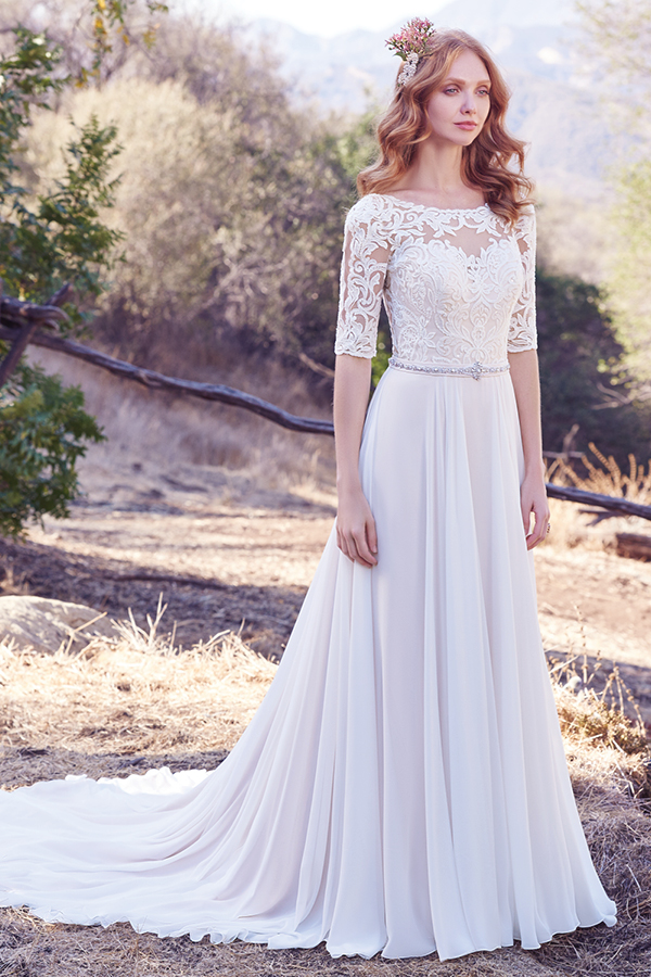 Este vestido linha-A apresenta um corpete em renda e mangas até aos cotovelos com efeito ilusão, assim como o seu decote em forma de U. Um cinto com cristais Swarovski e um decote em V nas costas confere um toque de romance surpreendente. Terminado com botões.
