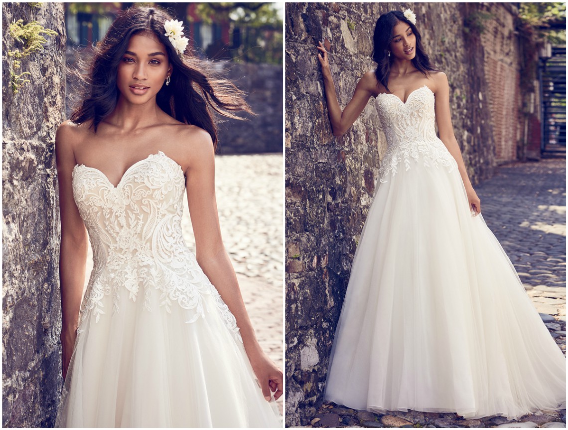 Este doce e simples vestido de noiva é composto por um corpete com motivos de renda e uma saia de tule. Um modelo cai-cai, com decote coração, com acabamentos de botões forrados sobre fecho zíper. <a href="https://www.maggiesottero.com/maggie-sottero/rayna/11187?utm_source=zankyou&utm_medium=gowngallery" target="_blank">Maggie Sottero</a>