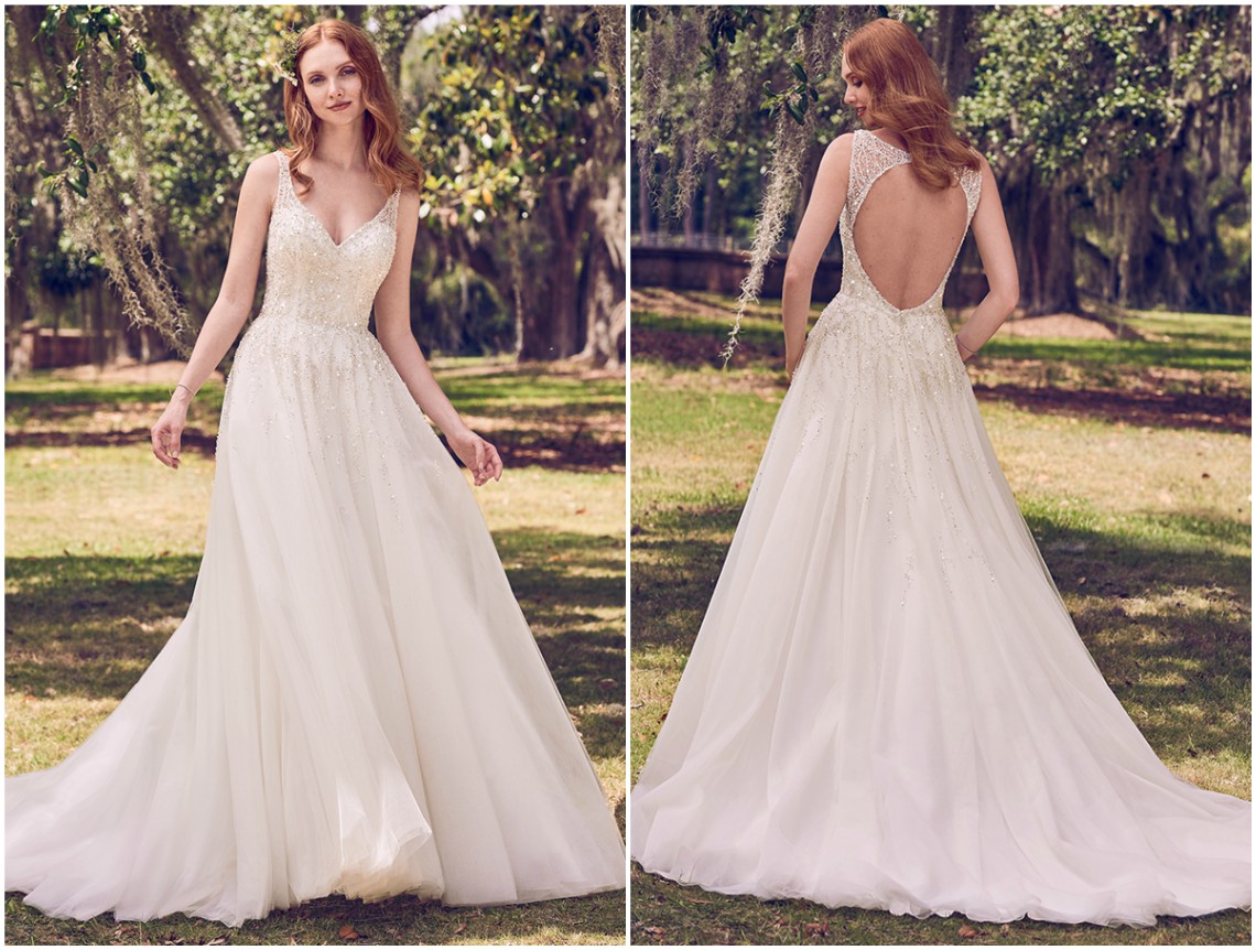 Vestido de noiva de inspiração vintage, com pedraria e cristais Swarovski no corpo que escorrem para uma saia em tule, que completa a silhueta linha A. Alças transparentes que saem do decote em V para terminar num decote redondo aberto nas costas, acentuado com cristais. Acabamentos com botões forrados e fecho zíper. <a href="https://www.maggiesottero.com/maggie-sottero/jace/11174?utm_source=zankyou&utm_medium=gowngallery" target="_blank">Maggie Sottero</a>