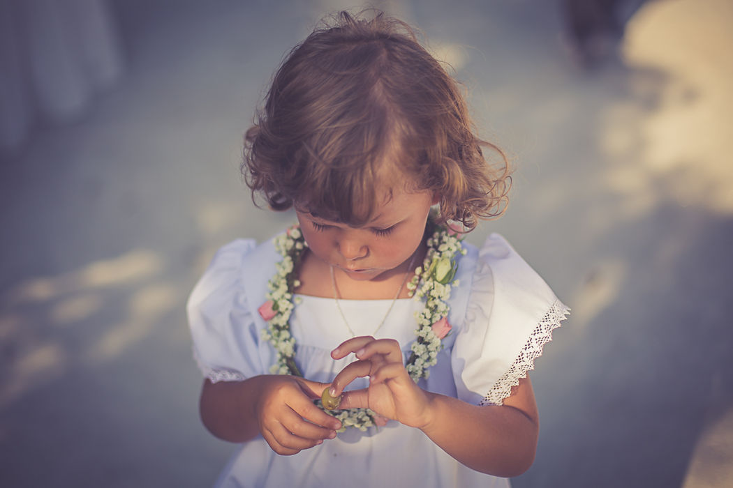 criança casamento com coroa de flores ao pescoço vestido festa branco