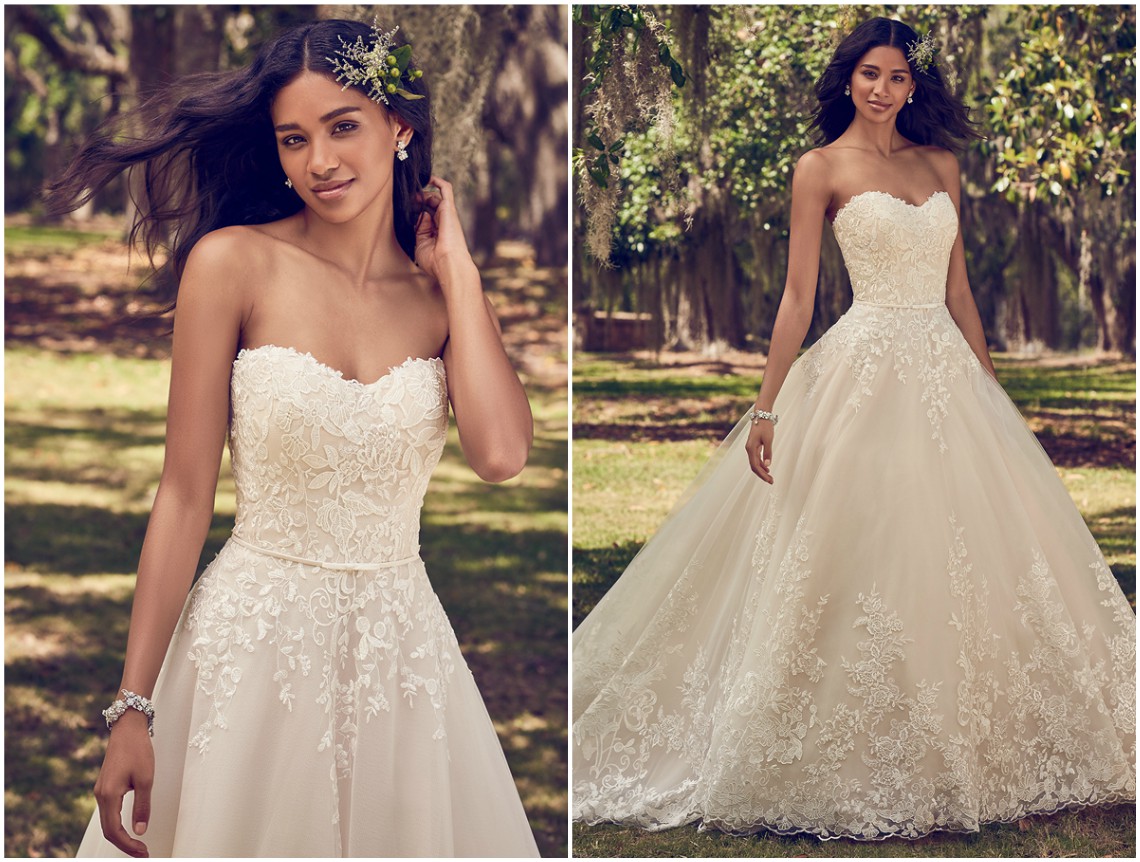 Aplicações de renda caem sobre o tule em cascata, neste vestido de noiva cai-cai com cinto. Acabamentos com botões forrados sobre fecho zíper e corselete interior. <a href="https://www.maggiesottero.com/maggie-sottero/viola/11199?utm_source=zankyou&utm_medium=gowngallery" target="_blank">Maggie Sottero</a>