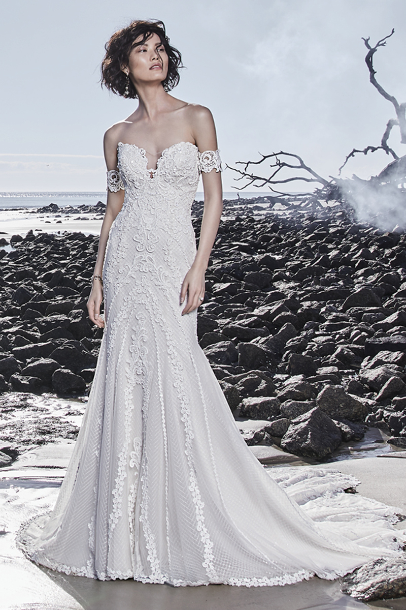 Um vestido de noiva fit-and-flare descontraído com um decote em forma de coração e um decote em U na parte das costas, que apresenta pormenores de renda. Um look verdadeiramente romântico. Terminado com botões de pérolas r um fecho.
<a href="https://www.maggiesottero.com/sottero-and-midgley/canton/11526">Sottero and Midgley</a>