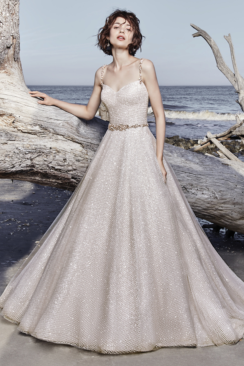 Apresentando glamour e sofisticação, este vestido de noiva moderno com corte de princesa apresenta um tule brilhante sobre um tule de seda. Cristais Swarovski acentuam o cinto, assim como as alças finas, que complementam o seu decote em forma de coração, assim como o decote em V nas costas. Terminado com botões de cristais
<a href="https://www.maggiesottero.com/sottero-and-midgley/vidette/11572">Sottero and Midgley</a>