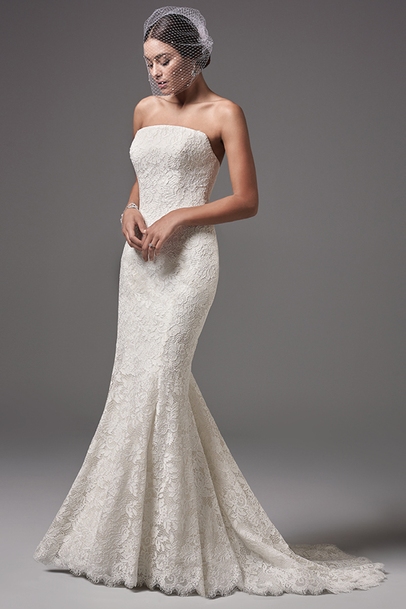 Este vestido fit-and-flare sem alças muito moderno e sofisticado apresenta detalhes floridos em renda e um decote direito. Terminado com botões em vez do fecho e um espartilho interior.
<a href="https://www.maggiesottero.com/sottero-and-midgley/linley/10236?utm_source=mywedding.com&utm_campaign=spring17&utm_medium=gallery" target="_blank">Sottero and Midlgey</a>